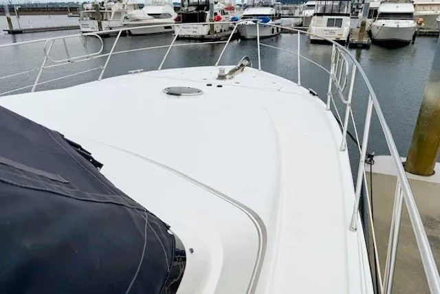 Slide: The Image of 1995 Symbol Pilothouse yacht docked at marina, showcasing sleek deck design and railing. - 11