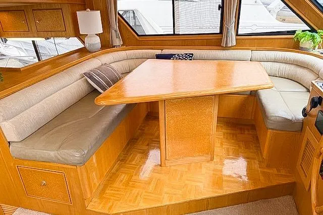 Slide: The Image of 1995 Symbol Pilothouse interior with wooden dining area and cushioned seating. - 16