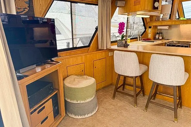 Slide: The Image of 1995 Symbol Pilothouse interior with kitchen, bar stools, TV, and decorative elements. - 18