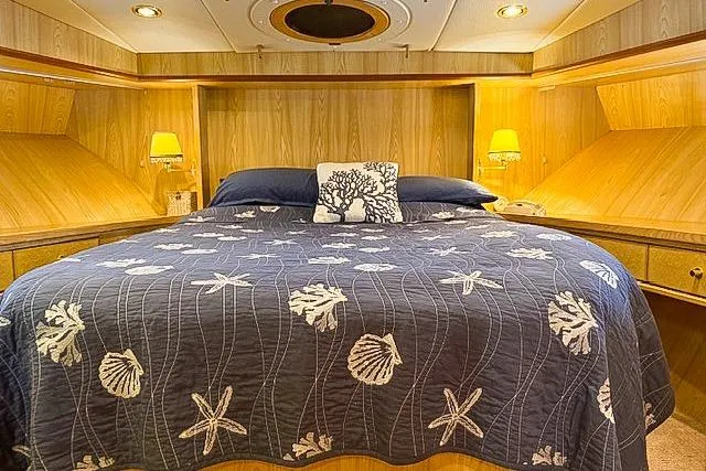Slide: The Image of Luxurious 1995 Symbol Pilothouse bedroom with nautical-themed bedding and warm lighting. - 2