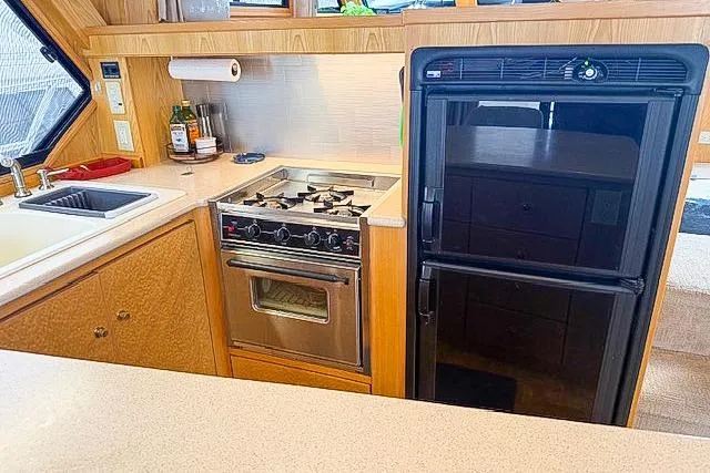 Slide: The Image of 1995 Symbol Pilothouse kitchen with stove, sink, and refrigerator in a compact layout. - 23