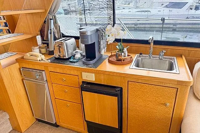 Slide: The Image of 1995 Symbol Pilothouse kitchen with appliances, sink, and window view of marina. - 24