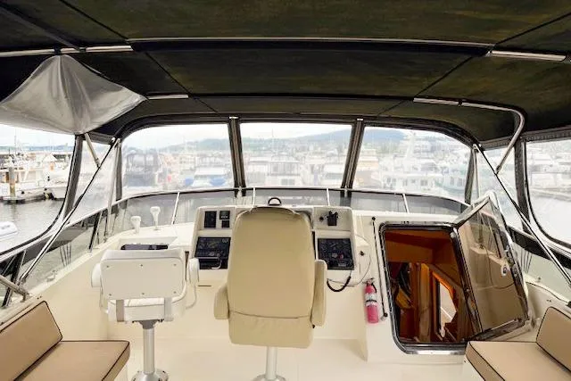 Slide: The Image of 1995 Symbol Pilothouse yacht interior with helm, seating, and marina view. - 3