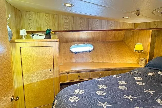 Slide: The Image of Cozy 1995 Symbol Pilothouse cabin with wood paneling, nautical bedding, and ambient lighting. - 33
