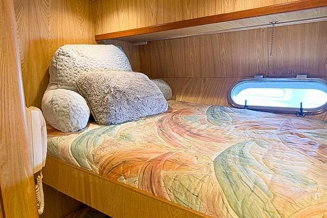 Slide: The Image of Cozy cabin bed in 1995 Symbol Pilothouse with colorful bedding and plush pillows. - 39