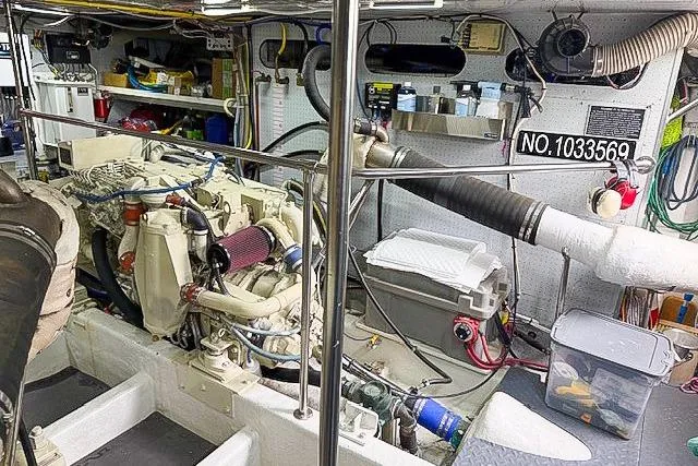 Slide: The Image of Engine room of a 1995 Symbol Pilothouse boat, showcasing mechanical components and storage. - 44
