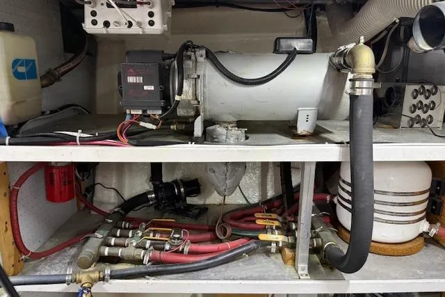 Slide: The Image of Engine room of a 1995 Symbol Pilothouse boat with mechanical components and wiring. - 49