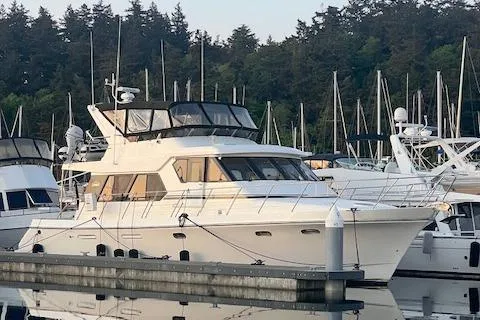 Slide: The Image of 1995 Symbol Pilothouse yacht docked in a marina with forested background. - 54