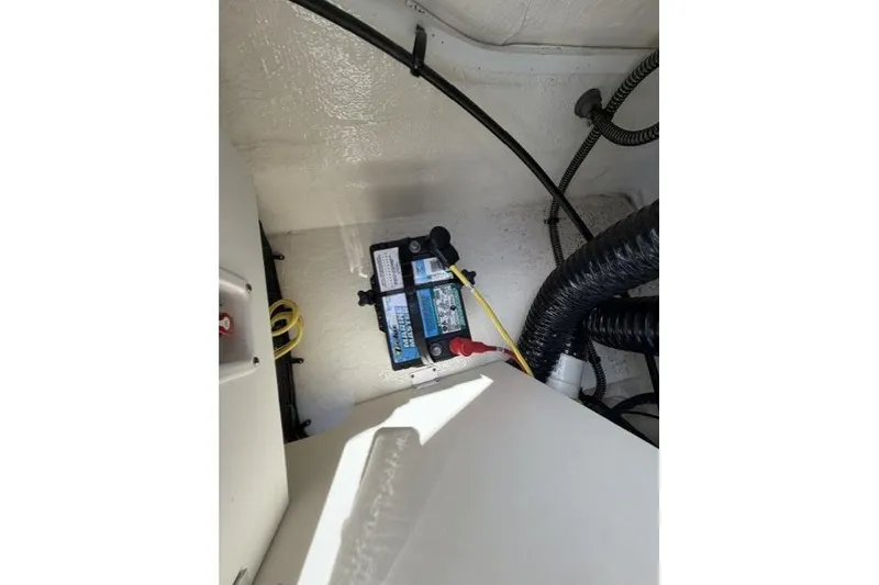 Slide: The Image of Battery compartment of 2022 Chaparral 23 SSi boat with wiring and connections. - 17