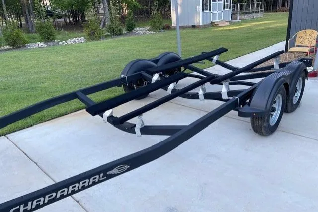 Slide: The Image of Trailer for 2022 Chaparral 23 SSi boat on driveway, surrounded by greenery. - 20