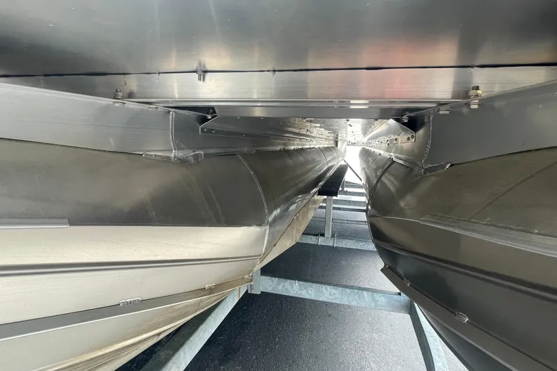 Slide: The Image of Underneath view of 2022 Manitou 23 Oasis pontoon boat on a trailer. - 10