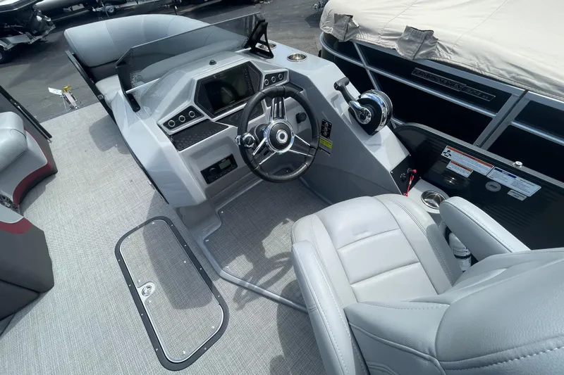 Slide: The Image of 2022 Manitou 23 Oasis boat interior with modern steering console and comfortable seating. - 11