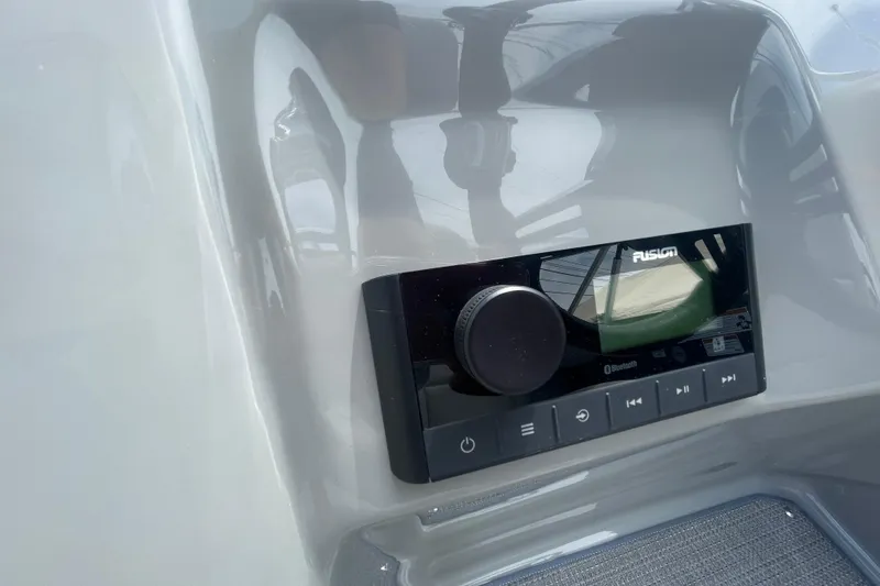 Slide: The Image of Control panel of 2022 Manitou 23 Oasis boat featuring a Fusion audio system. - 12