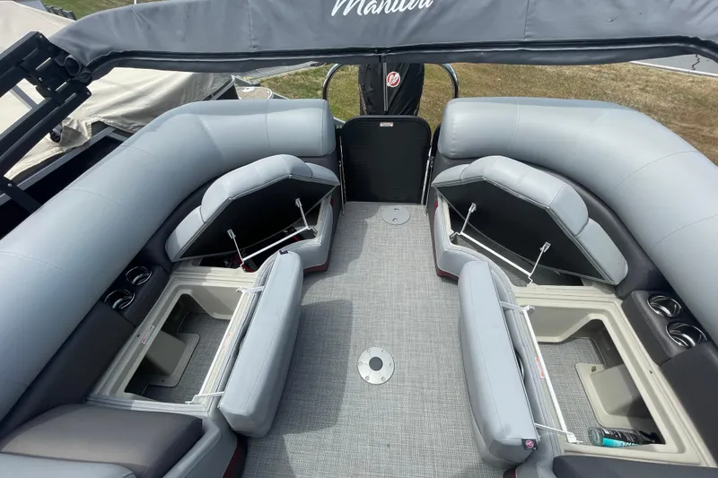 Slide: The Image of 2022 Manitou 23 Oasis pontoon boat interior with gray seating and storage compartments. - 14
