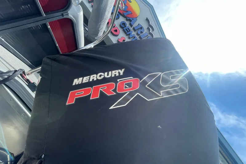Slide: The Image of Mercury Pro XS engine cover on 2022 Manitou 23 Oasis boat under bright sky. - 15