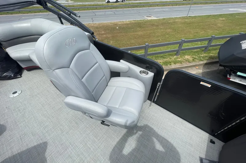 Slide: The Image of 2022 Manitou 23 Oasis boat with gray captain's chair and spacious deck. - 8