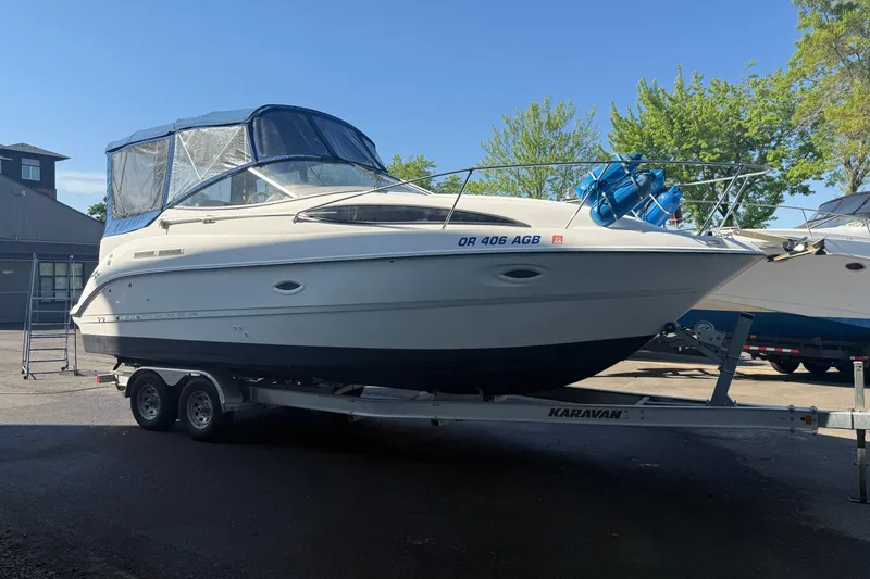 The Image of 2003 Bayliner 2655 Ciera boat on trailer, parked outdoors under clear blue sky. - 1