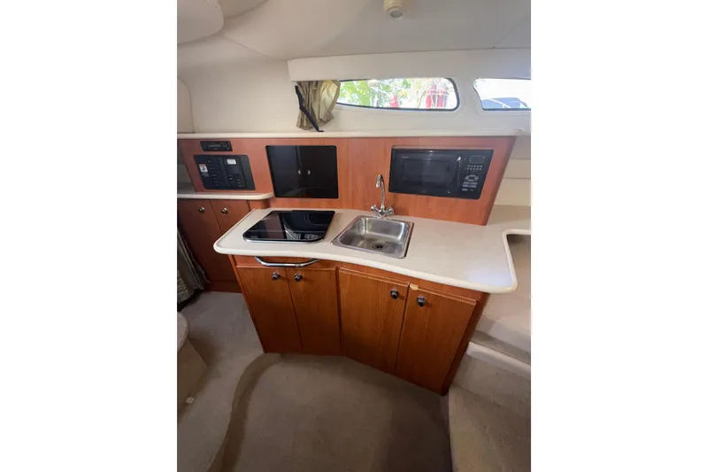 Slide: The Image of 2003 Bayliner 2655 Ciera cabin kitchen with sink, stove, and microwave. - 14
