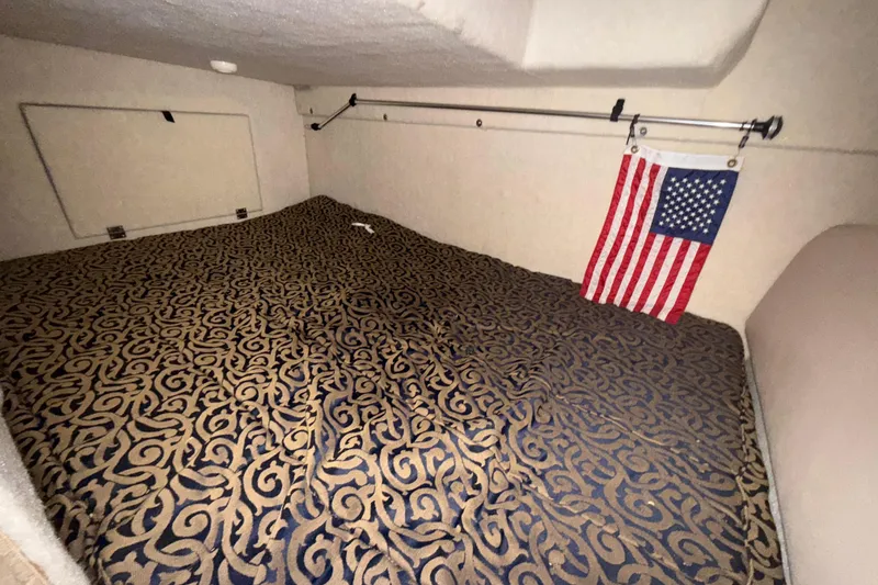 Slide: The Image of Interior cabin of 2003 Bayliner 2655 Ciera with patterned bedding and American flag. - 16