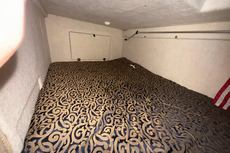 Slide: The Image of Interior cabin of 2003 Bayliner 2655 Ciera with patterned bedding and compact design. - 17