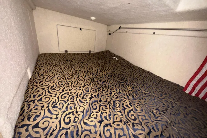 Slide: The Image of Interior cabin of 2003 Bayliner 2655 Ciera with patterned bedding and American flag. - 18