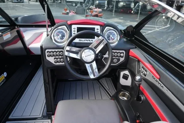 Slide: The Image of Interior of a 2014 Supra Launch SA 350-550 boat, featuring a sleek steering wheel and dashboard. - 14