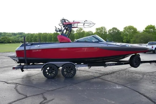 Slide: The Image of Red 2014 Supra Launch SA 350-550 boat on trailer, parked outdoors. - 4