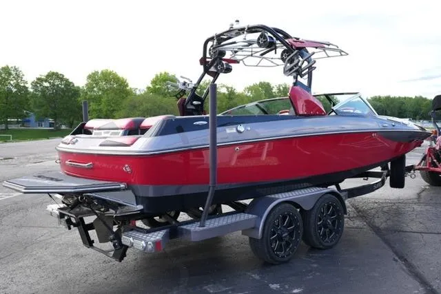 Slide: The Image of 2014 Supra Launch SA 350-550 boat on trailer, red and black design, parked outdoors. - 5