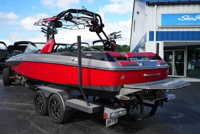Slide: The Image of Red 2014 Supra Launch SA 350-550 boat on trailer, parked outside dealership. - 7