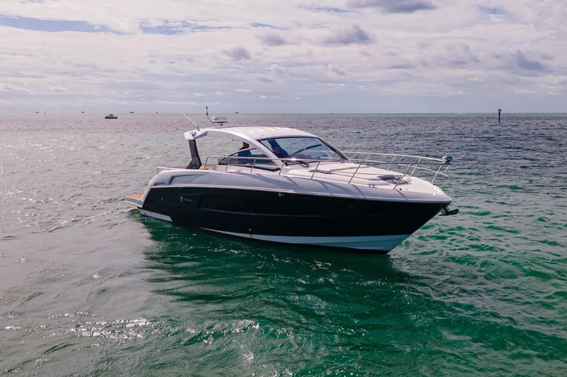 Slide: The Image of 2018 Cruisers Yachts 390 Express Coupe on open water under cloudy sky. - 2