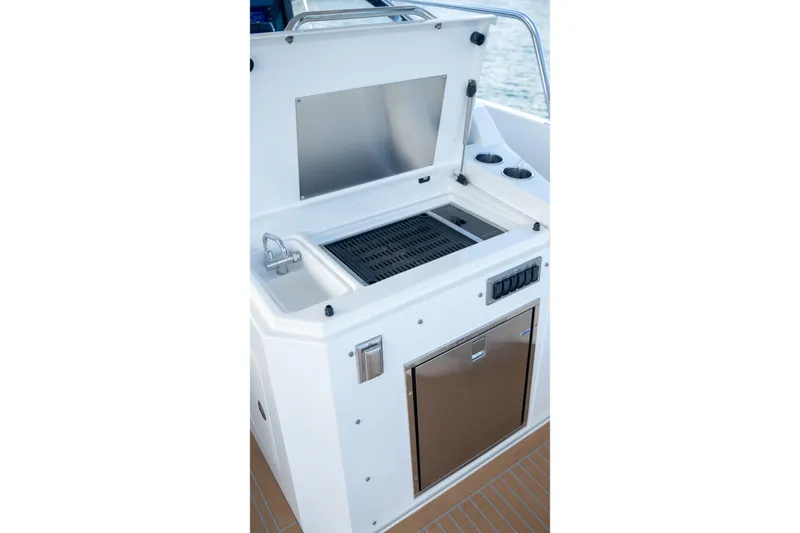 Slide: The Image of Outdoor kitchen area on 2018 Cruisers Yachts 390 Express Coupe with grill and sink. - 21