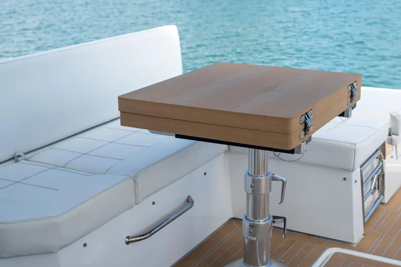 Slide: The Image of Luxurious seating and table on 2018 Cruisers Yachts 390 Express Coupe by the water. - 23