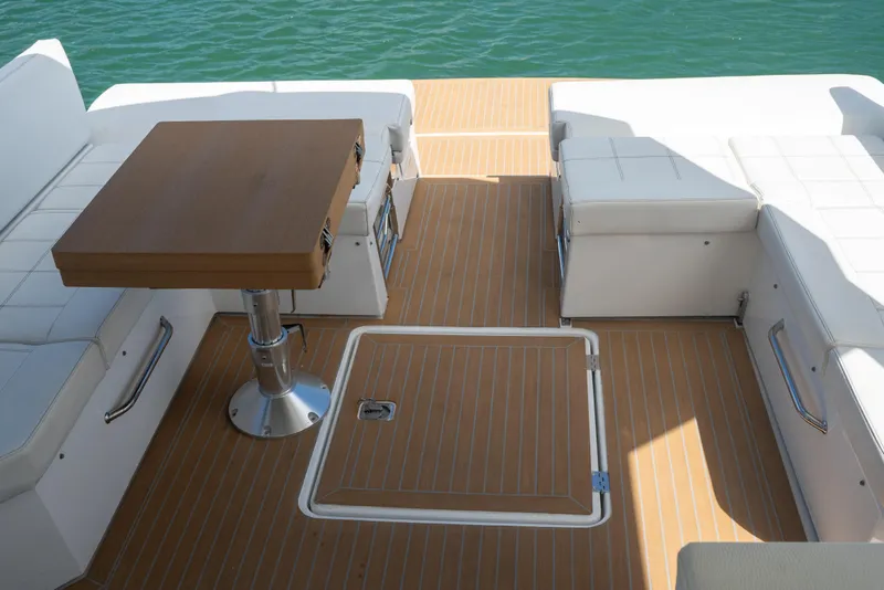 Slide: The Image of 2018 Cruisers Yachts 390 Express Coupe deck with seating and table, overlooking water. - 24