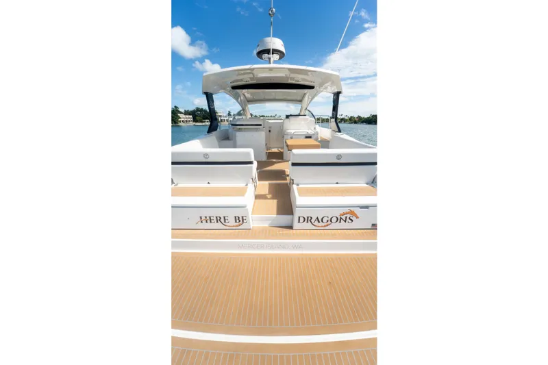 Slide: The Image of 2018 Cruisers Yachts 390 Express Coupe with spacious deck and seating, under clear blue sky. - 26