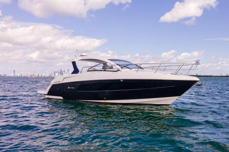 Slide: The Image of 2018 Cruisers Yachts 390 Express Coupe on open water under a partly cloudy sky. - 3
