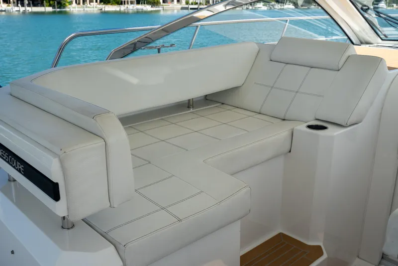 Slide: The Image of 2018 Cruisers Yachts 390 Express Coupe interior with white seating and scenic water view. - 33