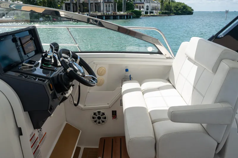 Slide: The Image of 2018 Cruisers Yachts 390 Express Coupe helm with luxurious seating and scenic water view. - 35