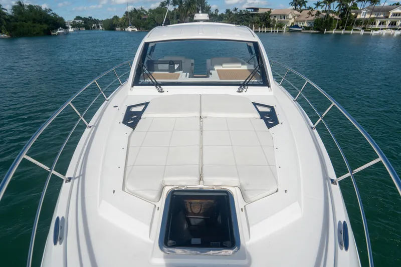 Slide: The Image of 2018 Cruisers Yachts 390 Express Coupe on serene water, showcasing sleek design and spacious deck. - 47