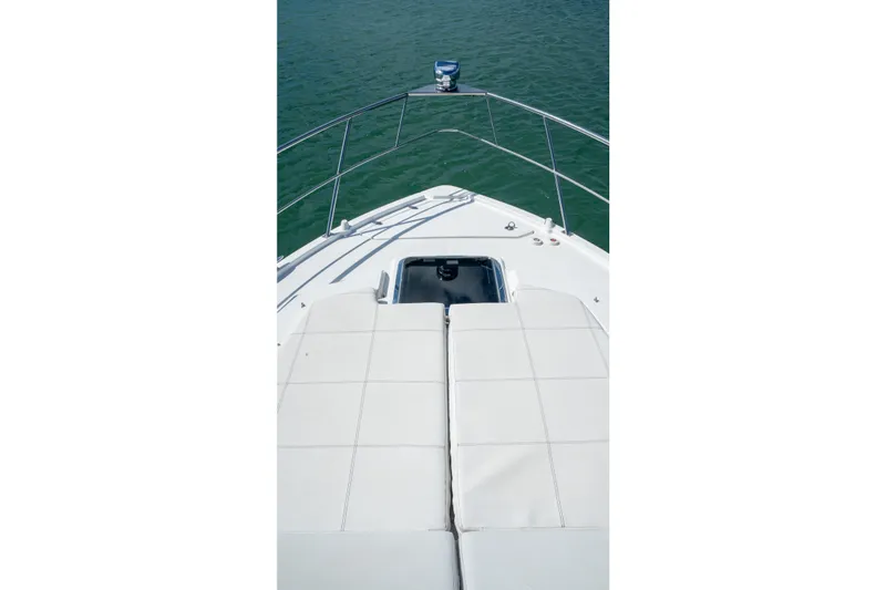 Slide: The Image of 2018 Cruisers Yachts 390 Express Coupe bow view with sunpad, on calm water. - 49