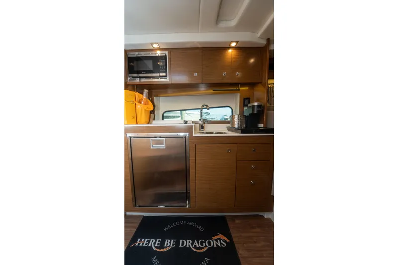 Slide: The Image of Interior of 2018 Cruisers Yachts 390 Express Coupe kitchen with modern appliances and wooden cabinetry. - 55