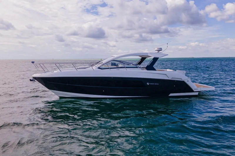 Slide: The Image of 2018 Cruisers Yachts 390 Express Coupe on open water under cloudy sky. - 6