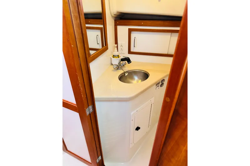 Slide: The Image of 2007 Back Cove 29 boat interior with compact sink and wooden cabinetry. - 10