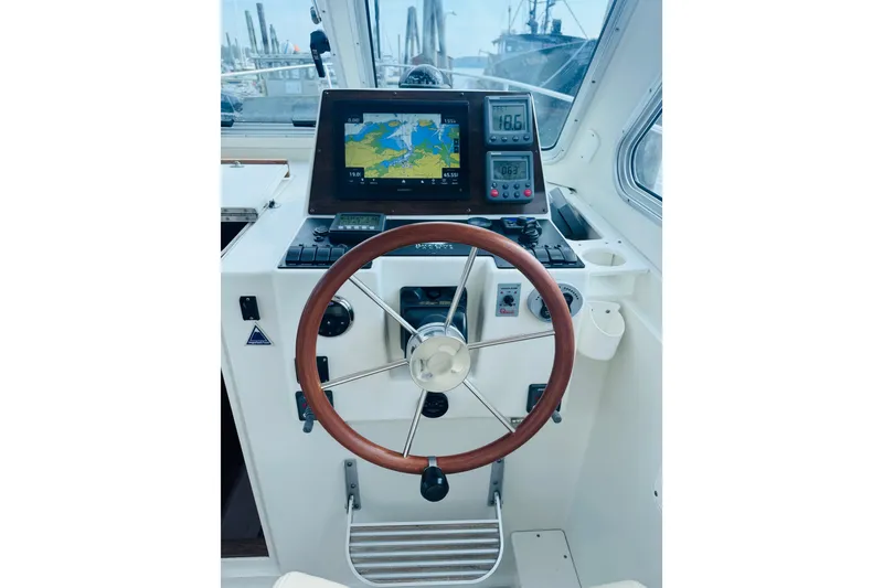Slide: The Image of Helm of 2007 Back Cove 29 boat with navigation equipment and wooden steering wheel. - 11