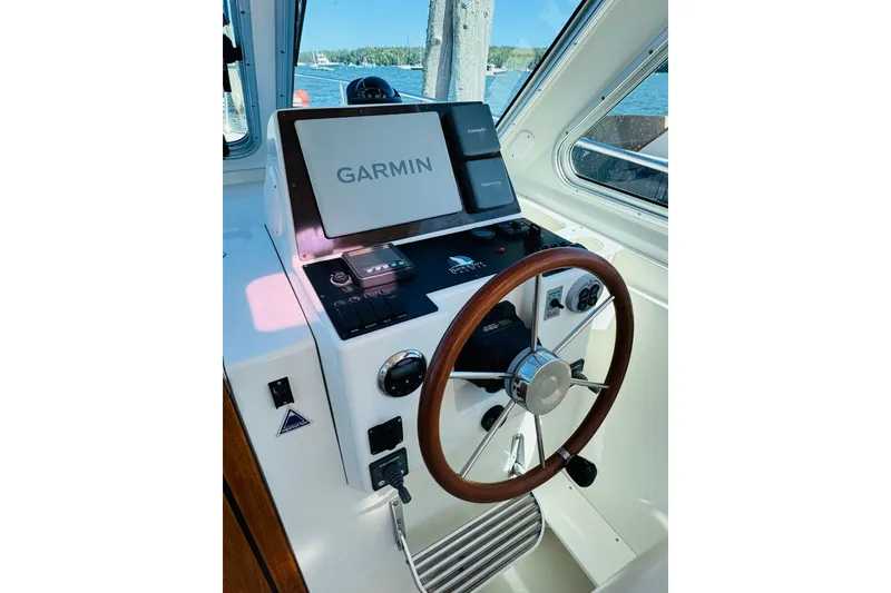 Slide: The Image of 2007 Back Cove 29 helm with Garmin navigation system and wooden steering wheel. - 12