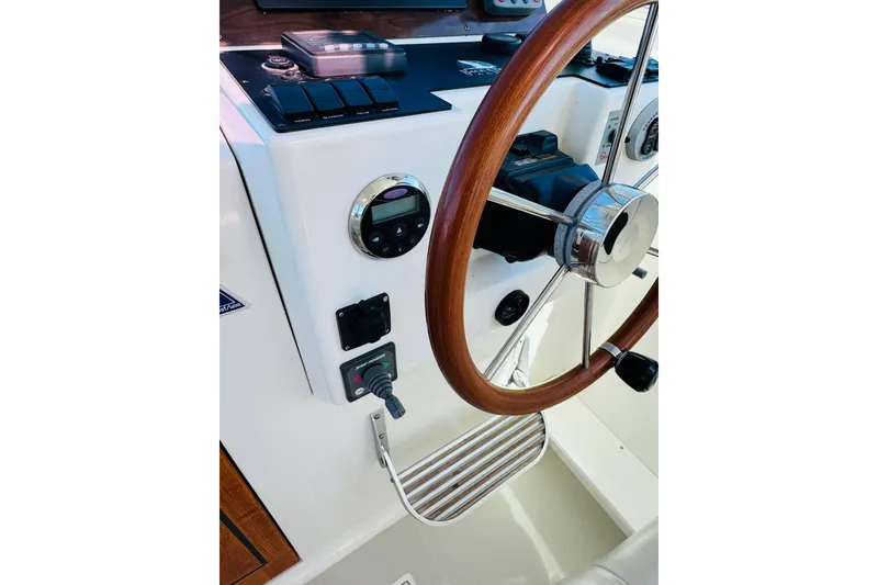 Slide: The Image of 2007 Back Cove 29 boat helm with wooden steering wheel and control panel. - 13