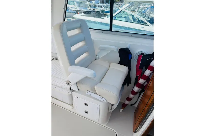 Slide: The Image of White captain's chair on 2007 Back Cove 29 boat, with life jackets and window view. - 17