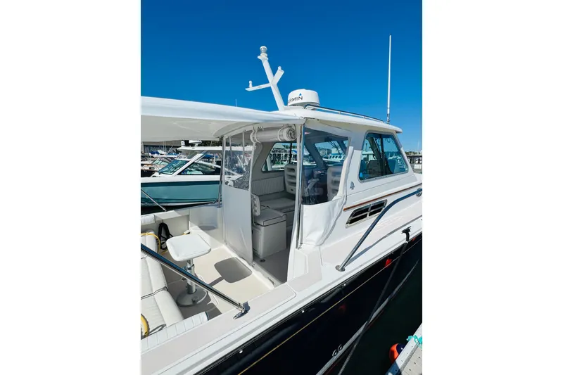 Slide: The Image of 2007 Back Cove 29 boat docked, showcasing sleek design and spacious cockpit area. - 25
