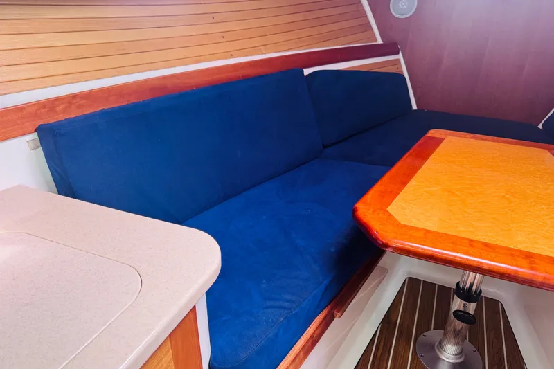 Slide: The Image of Interior of 2007 Back Cove 29 boat with blue seating and wooden table. - 3