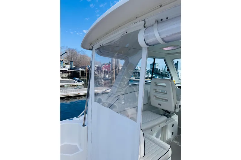 Slide: The Image of 2007 Back Cove 29 boat interior with seating, docked at marina under clear blue sky. - 30