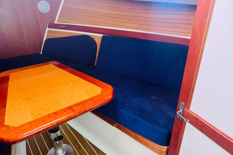 Slide: The Image of Interior of 2007 Back Cove 29 boat with blue seating and wooden table. - 4